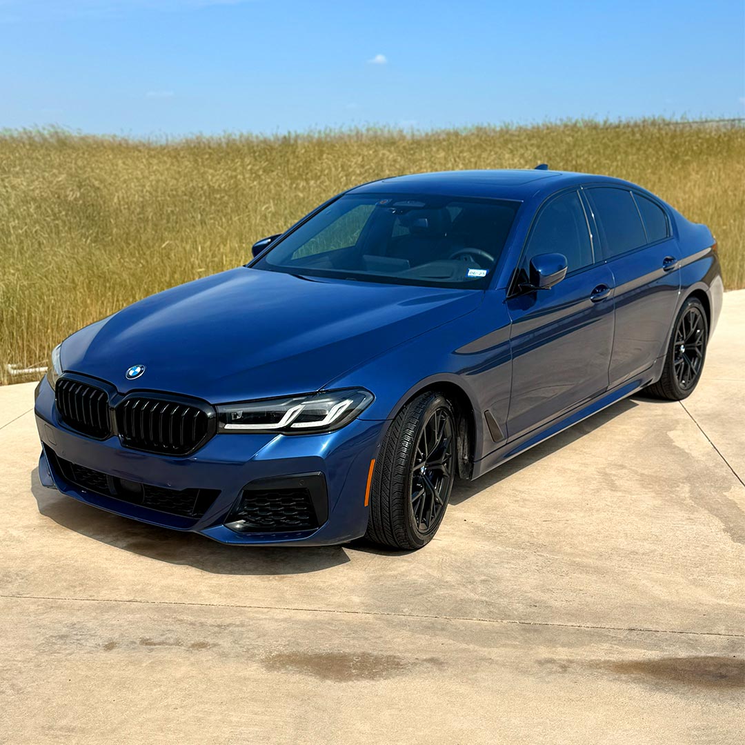 dark blue BMW clean car next to field