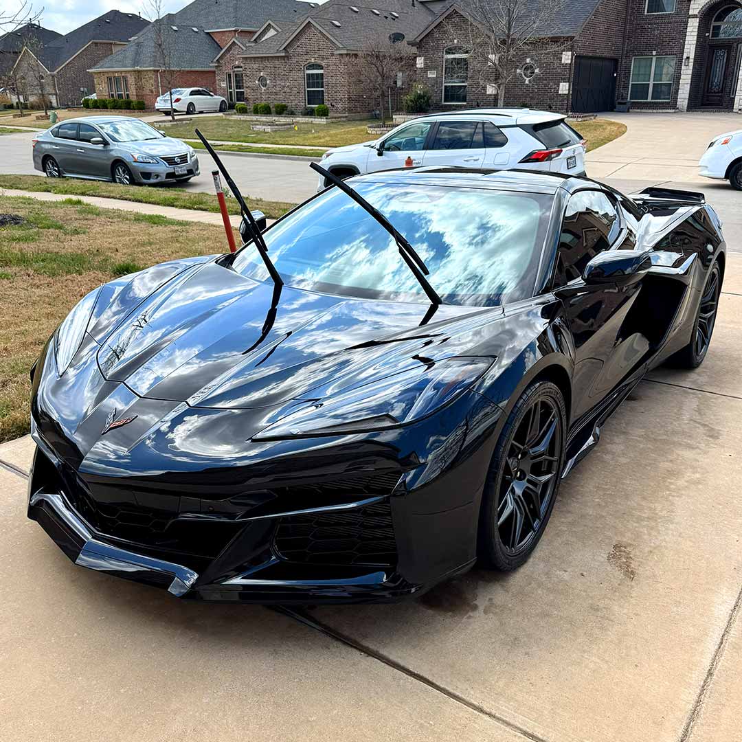 clean shiny black corvette in driveway