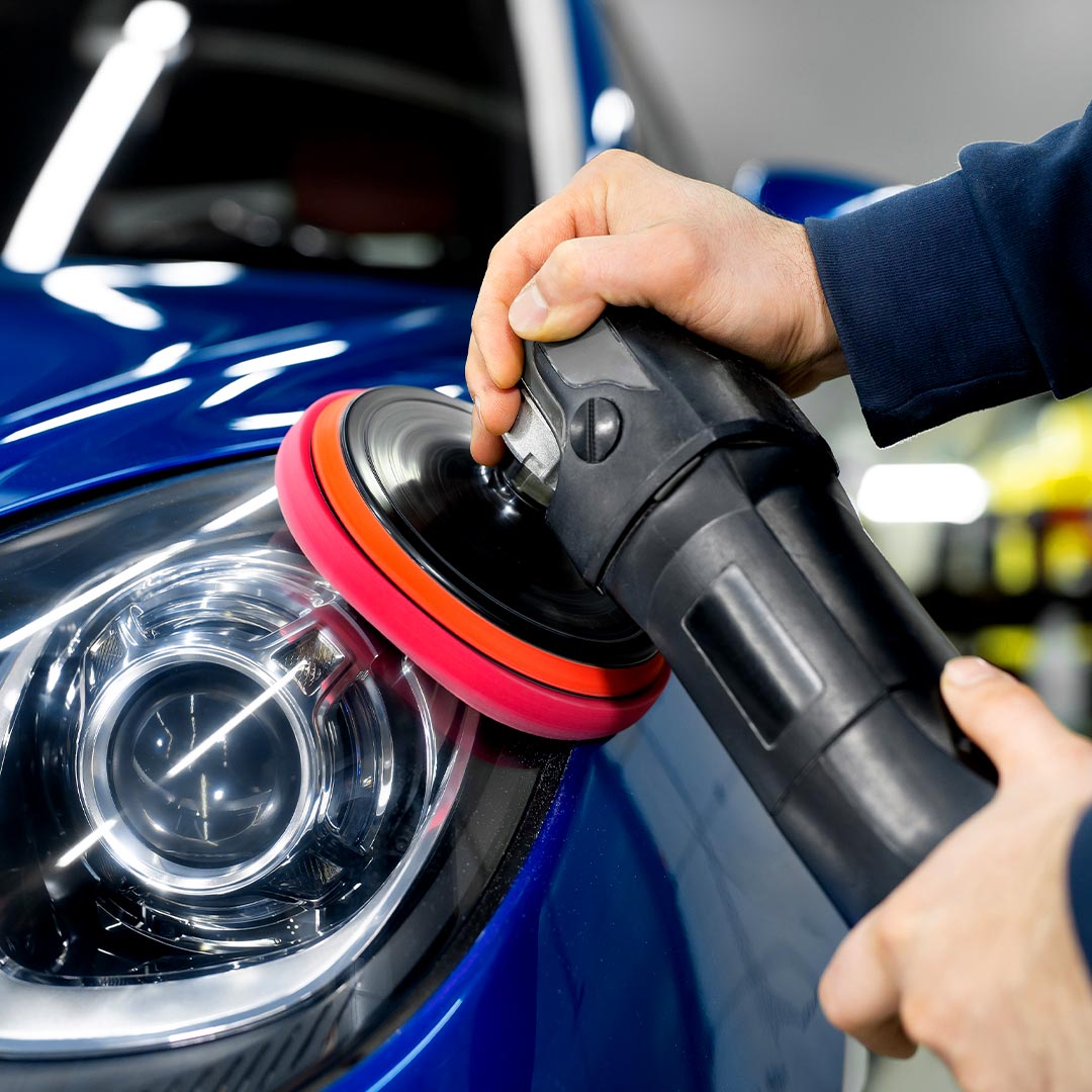 person performing headlight restoration
