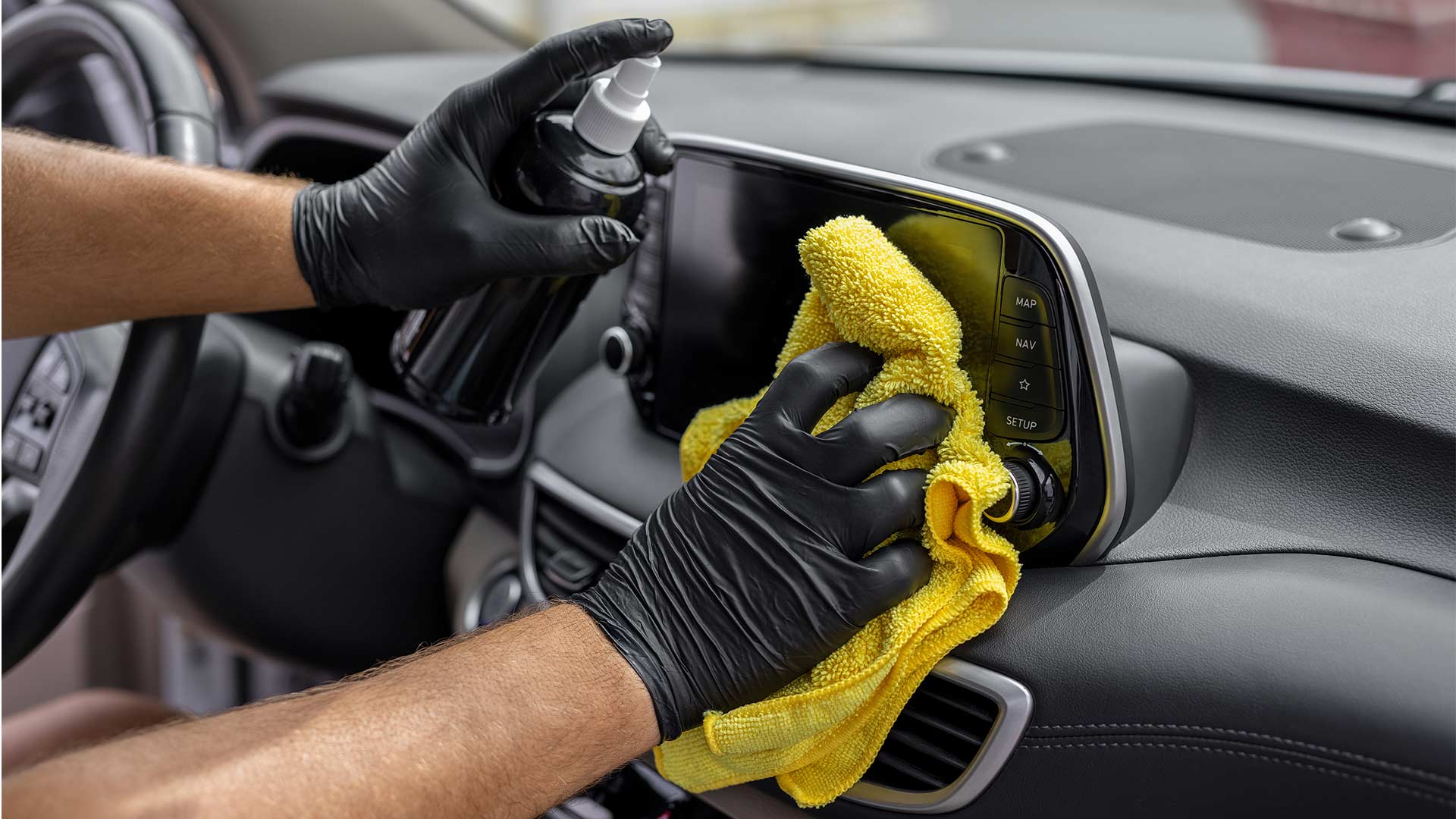 person spray protectant on interior dashboard
