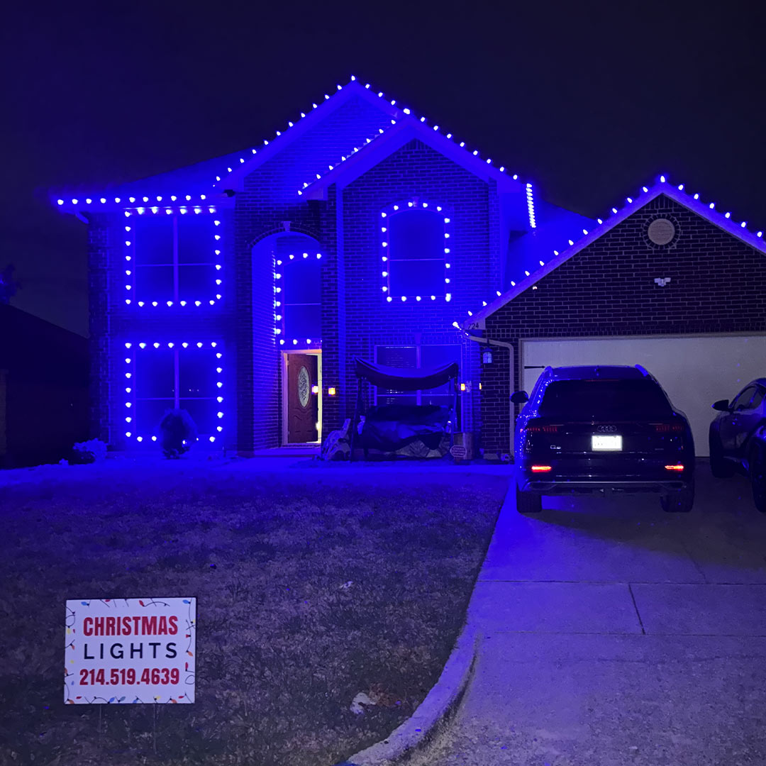 Blue LED Christmas lights outlining a two-story home's roofline and windows in the Dallas-Fort Worth area