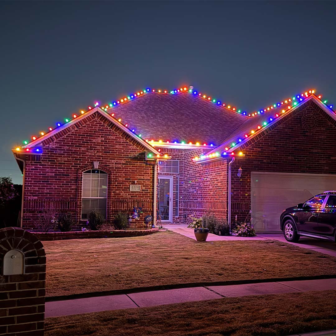 Colorful roofline Christmas lights illuminating a residential home in the Dallas-Fort Worth area