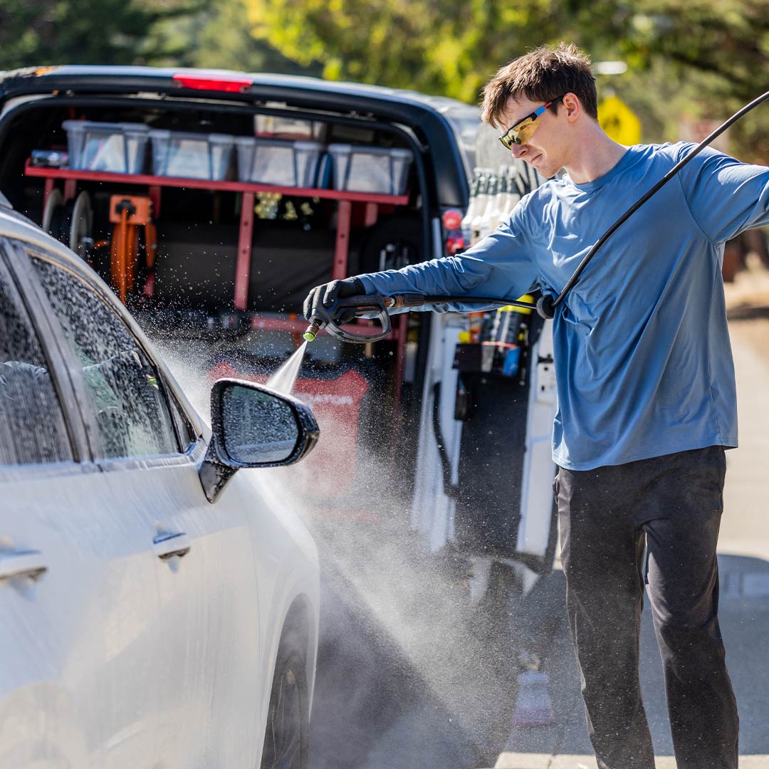 Mobile auto detailing technician washing a vehicle in Fort Worth TX